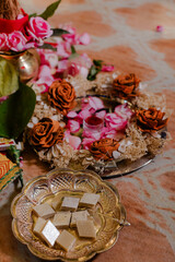 Festive arrangement with sweets, flowers, and decorative items, symbolizing a celebration or...