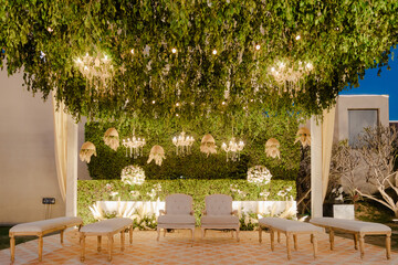 Elegantly decorated outdoor event space, ready for celebration. Lush greenery, delicate lighting, and sophisticated seating create a magical ambiance.