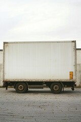 Box Truck Side View Stationary on Pavement Under Cloudy Sky Neutral Tone for Logistics or Delivery Concept
