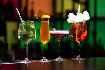 row of various colourfull alcoholic cocktails on a bar desk. Glasses of differen shapes. selective focus
