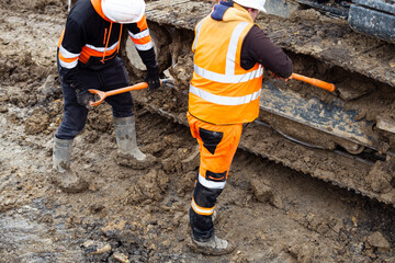 Heavy machinery maintenance is being performed by driver on construction project