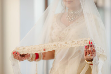 Bridal Elegance: A veiled bride in a traditional white dress, adorned with intricate jewelry,...