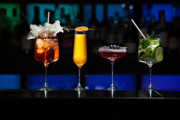 row of various colourfull alcoholic cocktails on a bar desk. Glasses of differen shapes