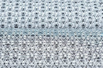 Close-up of the roll of white plastic geogrid mesh with intricate pattern and texture