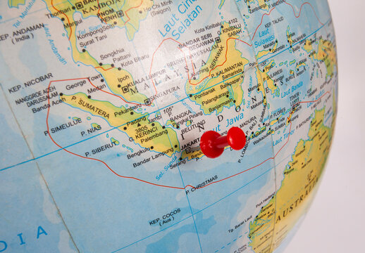 The city of Jakarta and Indonesia as a whole on a globe map is marked by a red pin as a location indicator. Jakarta is the capital and most important city in Indonesia.