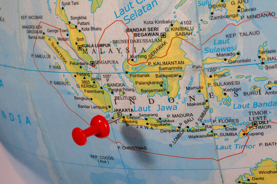 The city of Jakarta and Indonesia as a whole on a globe map is marked by a red pin as a location indicator. Jakarta is the capital and most important city in Indonesia.