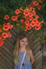 Portrait of adorable little fashionable 7 years old girl leaning on the vintage wooden door with...