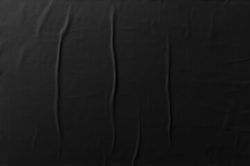 Crumpled black paper texture, glued poster pattern with wrinkles for mockup, abstract background