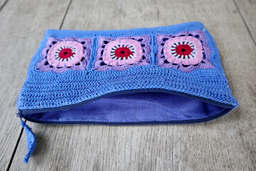 A vibrant crochet piece showcases meticulous hook work. Floral motifs, arranged in squares,...