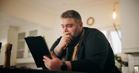 Tablet, stress and chef in kitchen for online recipe planning, instructions or research for cook book. Shock, digital technology and male person reading negative culinary review on restaurant in home