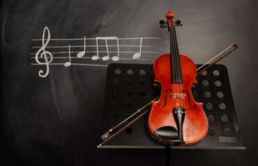 Classical violin on black background with music notes.