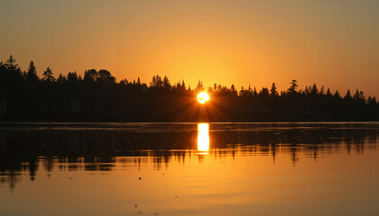 Fototapeta premium Beautiful sunset over calm lake reflecting trees and sky 