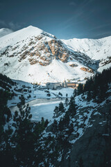 Vall de Nuria Monastery, Spain, hidden among the trees of the forest in the snowy mountains.