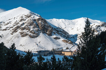 Vall de Nuria Monastery, Spain, hidden among the trees of the forest in the snowy mountains.