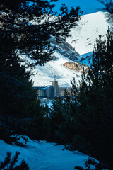 Vall de Nuria Monastery, Spain, hidden among the trees of the forest in the snowy mountains.