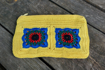 A vibrant crochet piece showcases meticulous hook work. Floral motifs, arranged in squares,...