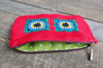 A vibrant crochet piece showcases meticulous hook work. Floral motifs, arranged in squares,...