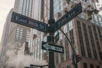 Paisaje urbano de Nueva York con señales de tráfico, semáforos y chimeneas de vapor. Señal de tráfico en la intersección de la calle 38 Este y la Quinta Avenida. Noviembre de 2019.