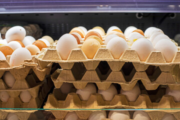 chicken white and brown eggs in a cardboard container in the supermarket