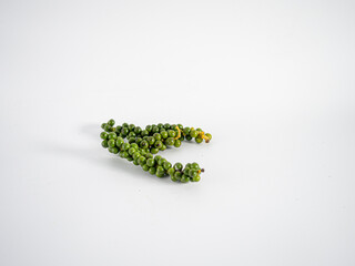 Curled peppercorn stem positioned flat with light directional shadows to highlight freshness, texture, and suitability for spice-related promotional content.