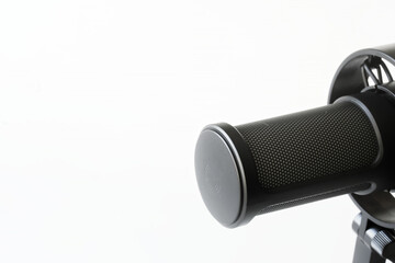 A close-up of a broadcast microphone on a white background, ideal for podcasting and voice recording projects. Photo. Copy space