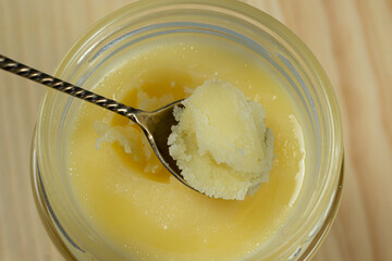 Ghee butter clarified butter jarred in a spoon top view.