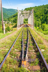 old railroad passes through the valley. transportation background. mountainous countryside in...