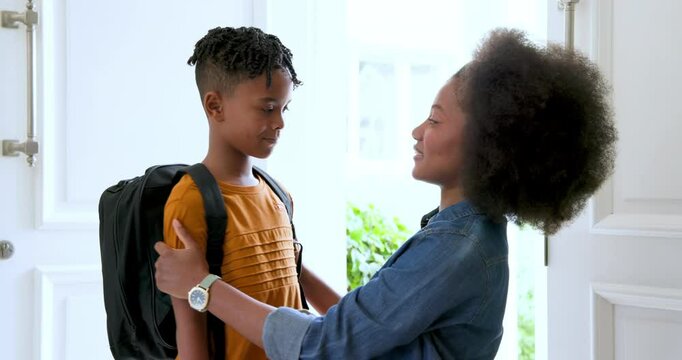 Happy black mother talking to and high fiving with her multiracial son before him leaving for school