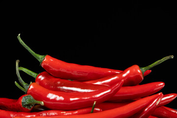 Pile of hot chili peppers on a black background space for text