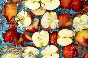Juicy summer or autumn background. Red apple halves and in water.