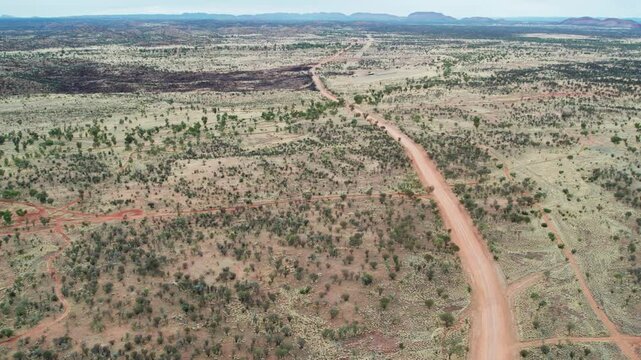 Panning aerial view above Udoolya Road, near Alice Srings, Mparntwe. Northern Territory, Australia. August 2022.