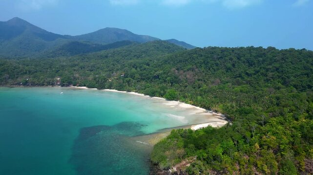ong beach at koh chang island showing turquoise water and green rainforest in Trat Province, Thailand. Majestic aerial view flight descending drone