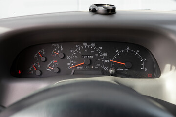 Dashboard cluster with analog gauges in a 2000s American pickup truck, showing speedometer, RPM, temperature, and fuel levels with steering wheel partially visible.