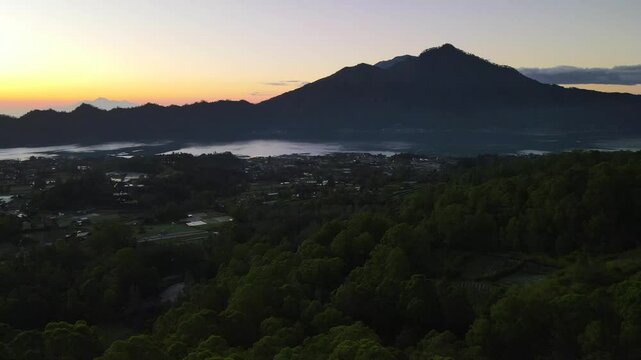 Cinematic drone flight at sunrise over Lake Batur and Mount Abang, Kintamani Bali Indonesia.