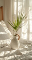 Palm frond in vase with sunlit bedroom.