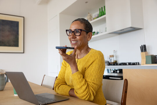 Mature woman using aritificial intelligence at home - Powered by Adobe