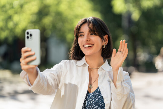 A selfie for the loved ones. Attractive woman with short hair student, chatting with her parents or friends from far away while on the move