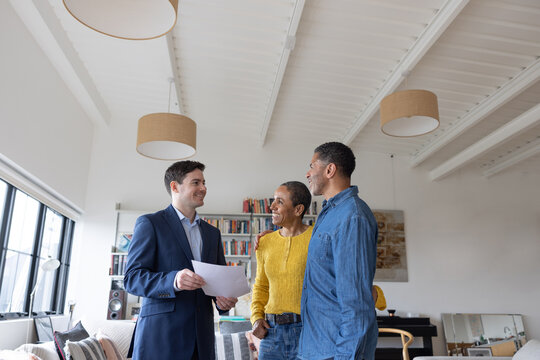 Happy senior couple looking at new home with a real estate agent