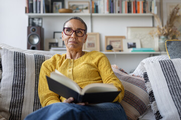 Thoughtful mature reader enjoying a quiet moment at home