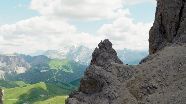 Slow panning drone shot of one man standing on top of Forcella del Sassolungo near Toni Demetz Hut, Dolomites, Italy