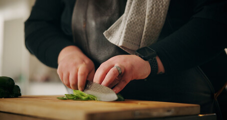 Chef, hands and man in kitchen, cutting vegetables and nutrition with meal prep, culinary skills and ingredients. Closeup, home or expert with utensils, cook and chopping board with recipe or cuisine