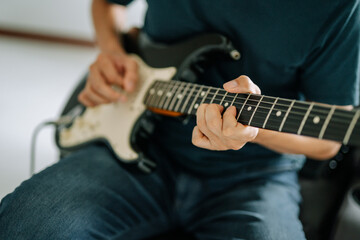 A person immersed in the art of playing the guitar, their fingers dance across the fretboard,...