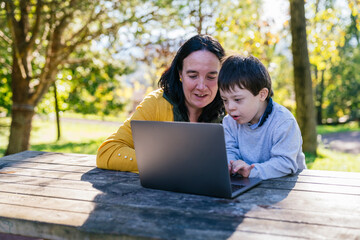Mother and Son Enjoy Learning on a Laptop Outdoors