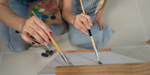 Activity mother and daughter painting close up of hands creating art