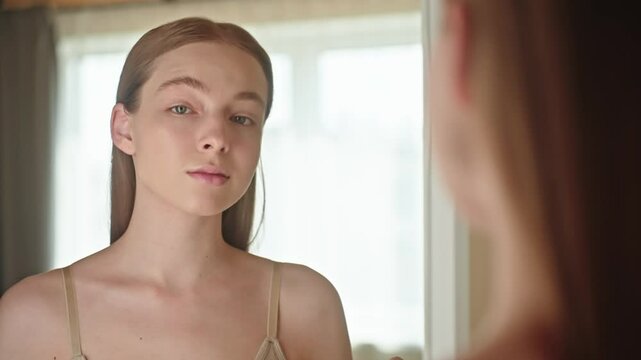 Young woman applying mascara in front of a mirror. Confident and focused, she enhances her eyelashes as part of her daily makeup routine. Concept for mascara product advertising and beauty content.