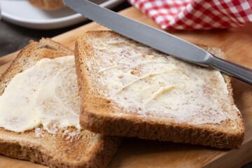 Sliced fresh bread and butter on wooden table. Close up