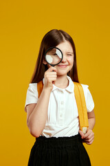 Joyful child with a magnifying glass, intently examining something, expressing curiosity and engagement. Ideal for educational campaigns and learning resources.