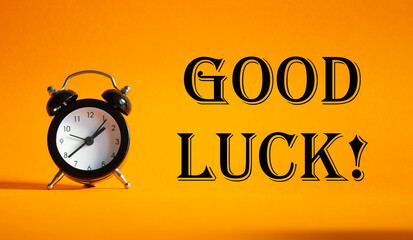 Good luck symbol. Beautiful orange background with alarm clock. Business and Good luck concept. Copy space.