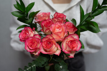 girl holding a bouquet of pink roses in her hands