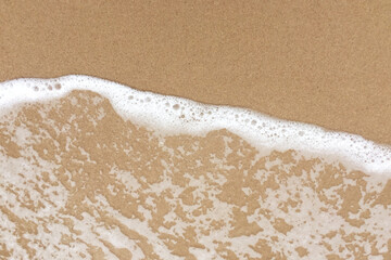 White foam created by waves hitting the sandy beach with freshness natural clean white shapes. Image use for travel presentation background.
